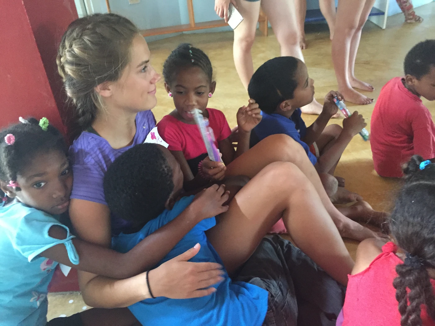 Volunteer seated with children during a structured youth program