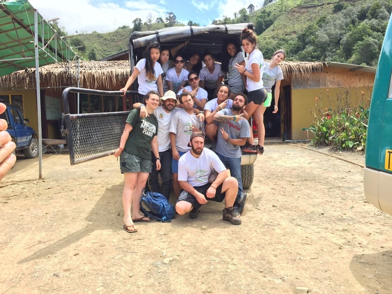 Volunteers crowded onto the back of a truck at a coffee farm, laughing
